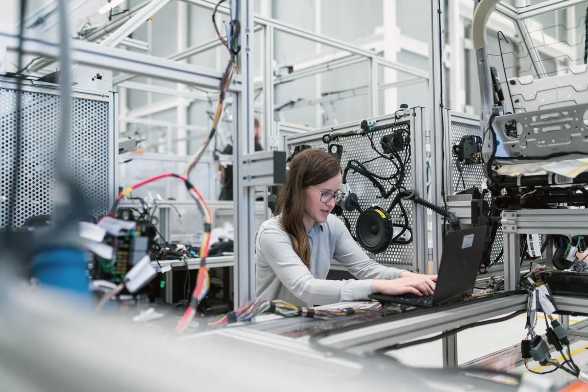 An engineer working on a laptop on a factory floor